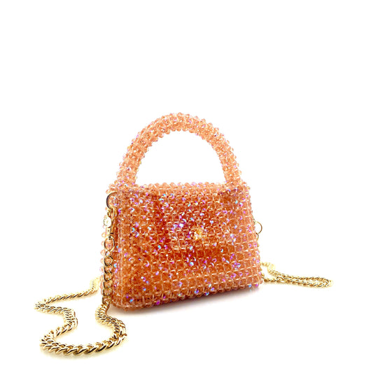 coral pink beaded handbag with gold chain. on white background