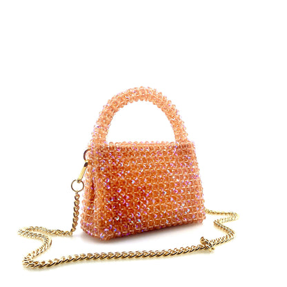 coral pink beaded handbag with gold chain. on white background 