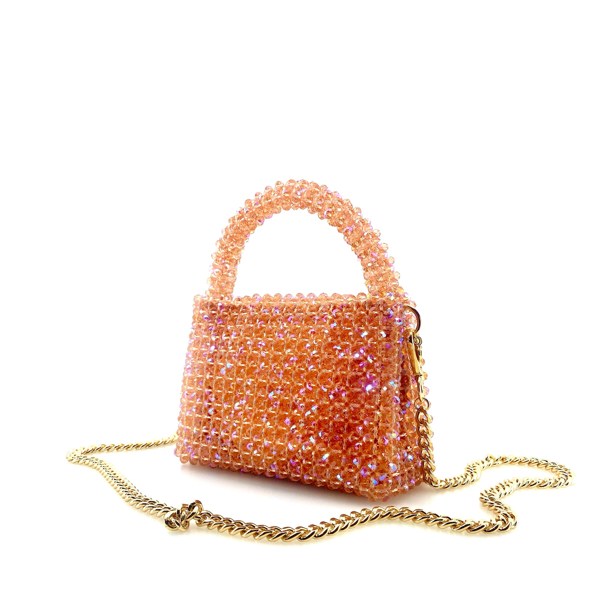 coral pink beaded handbag with gold chain. on white background 