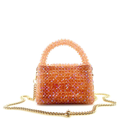 coral pink beaded handbag with gold chain. on white background 