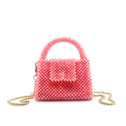 pink beaded handbag with gold chain. on white background