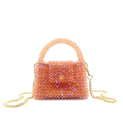 rotating image of coral pink beaded handbag with gold chain. on white background 